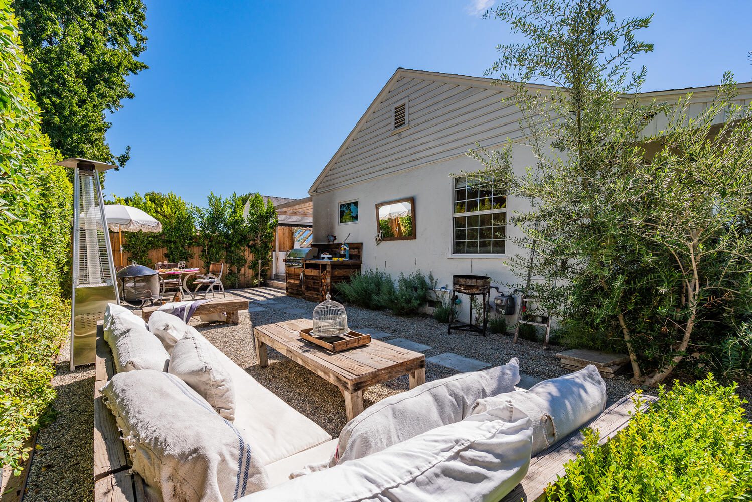 A patio with couches and tables in the middle of it.