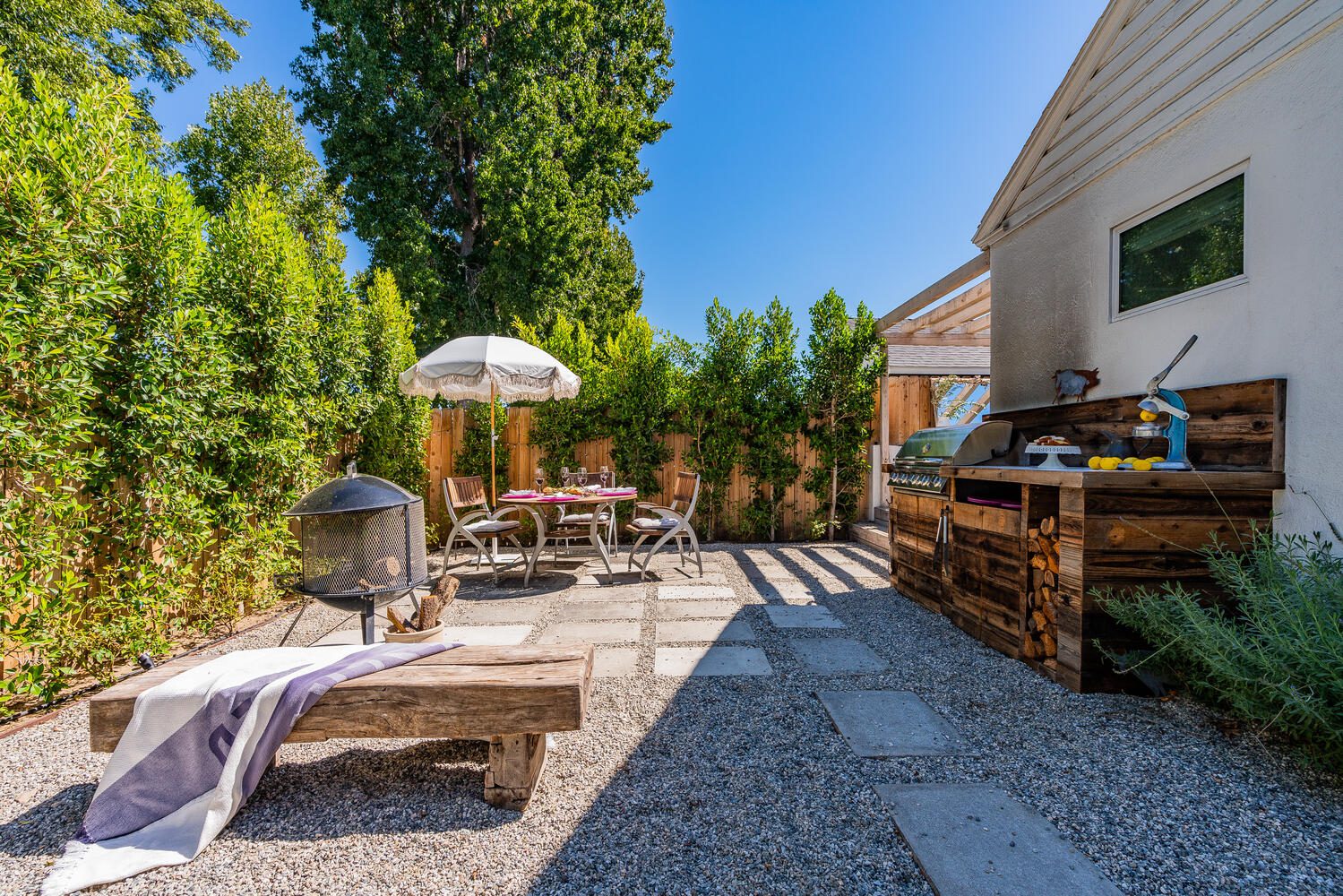 A patio with an outdoor grill and table.