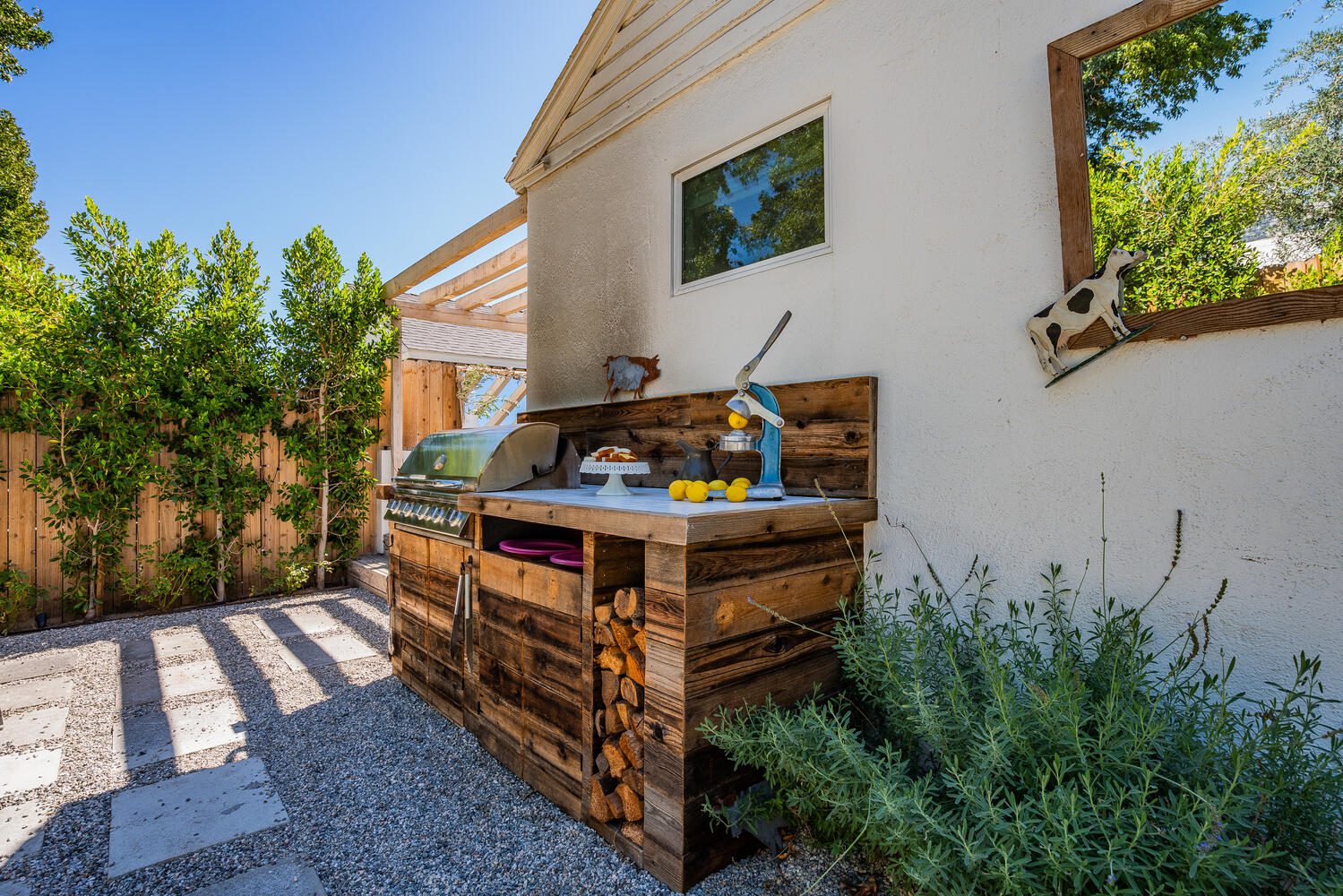 A wooden bench with an outdoor sink in the middle of it.