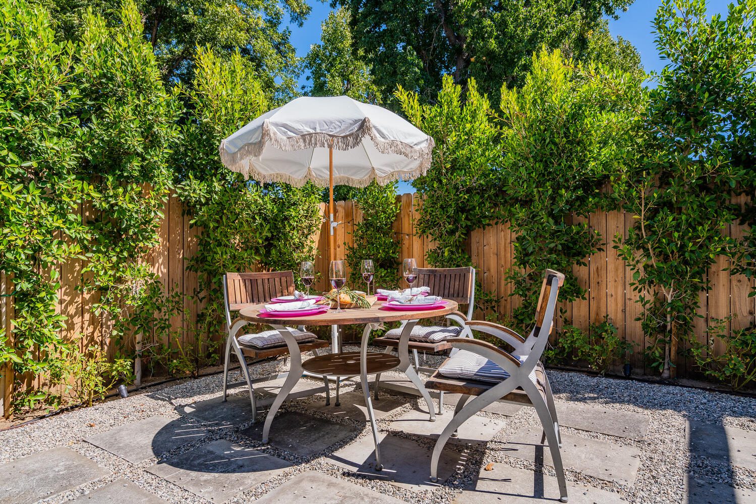 A table and chairs with an umbrella on the patio.