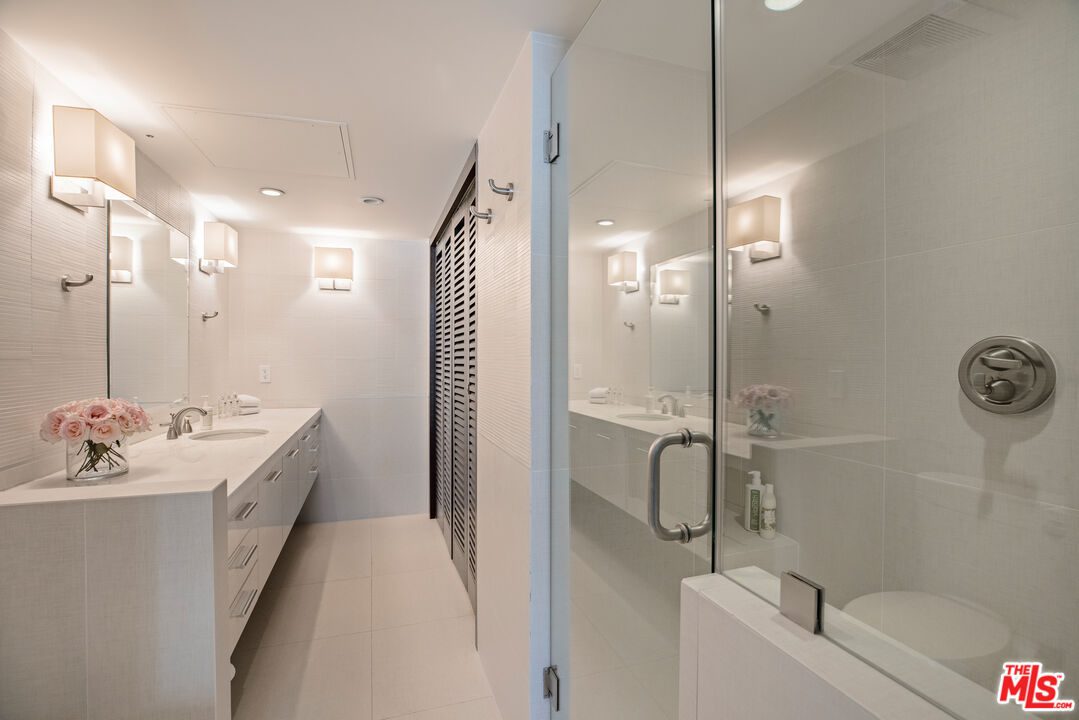 A bathroom with a shower, toilet and sink.