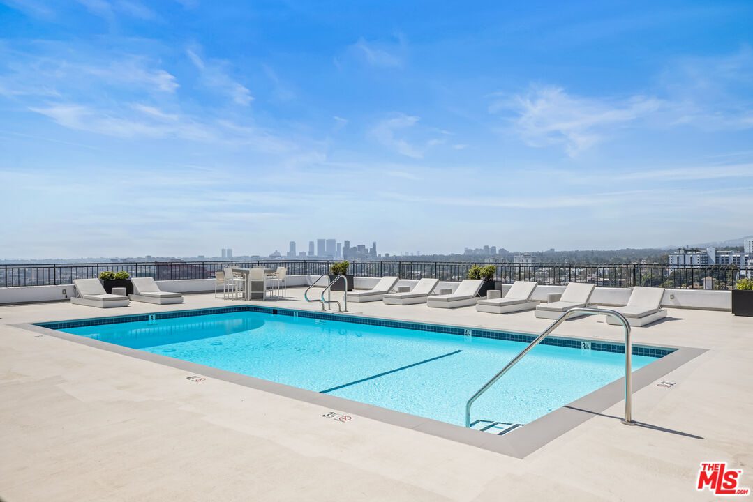 A large swimming pool with chairs and umbrellas