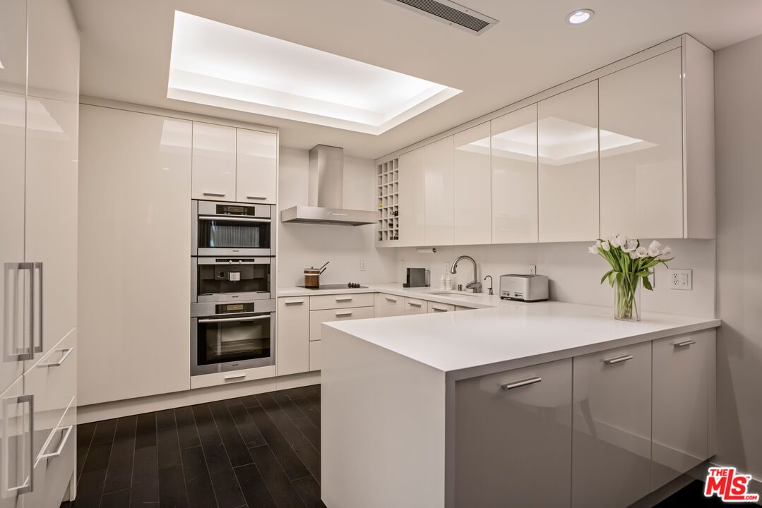 A kitchen with white cabinets and black floor