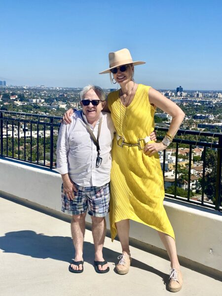 A woman and man standing on top of a building.