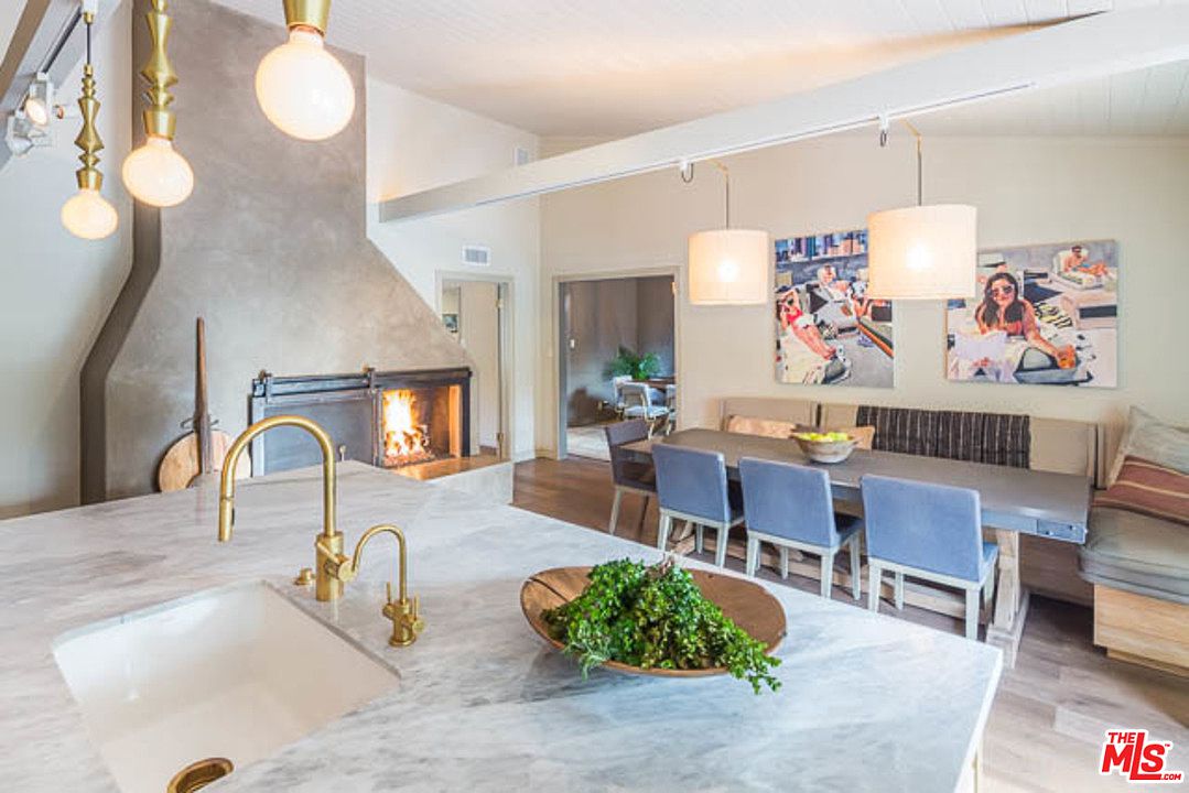 A kitchen with a fireplace and dining room table.