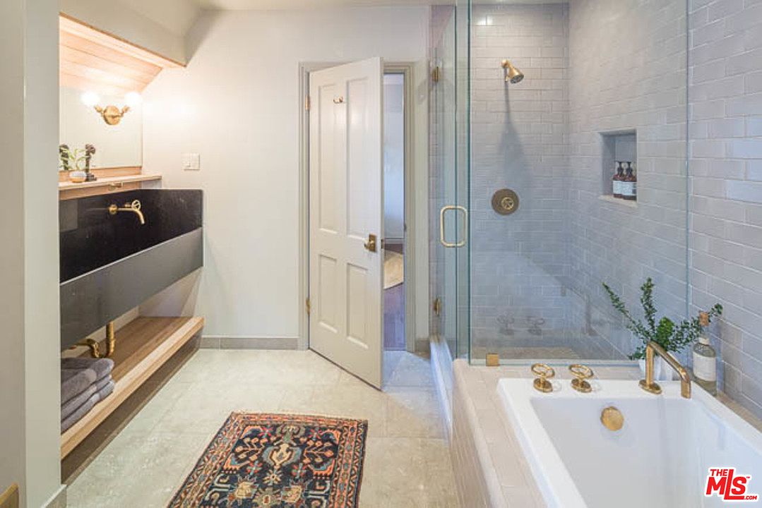 A bathroom with a tub, shower and sink.