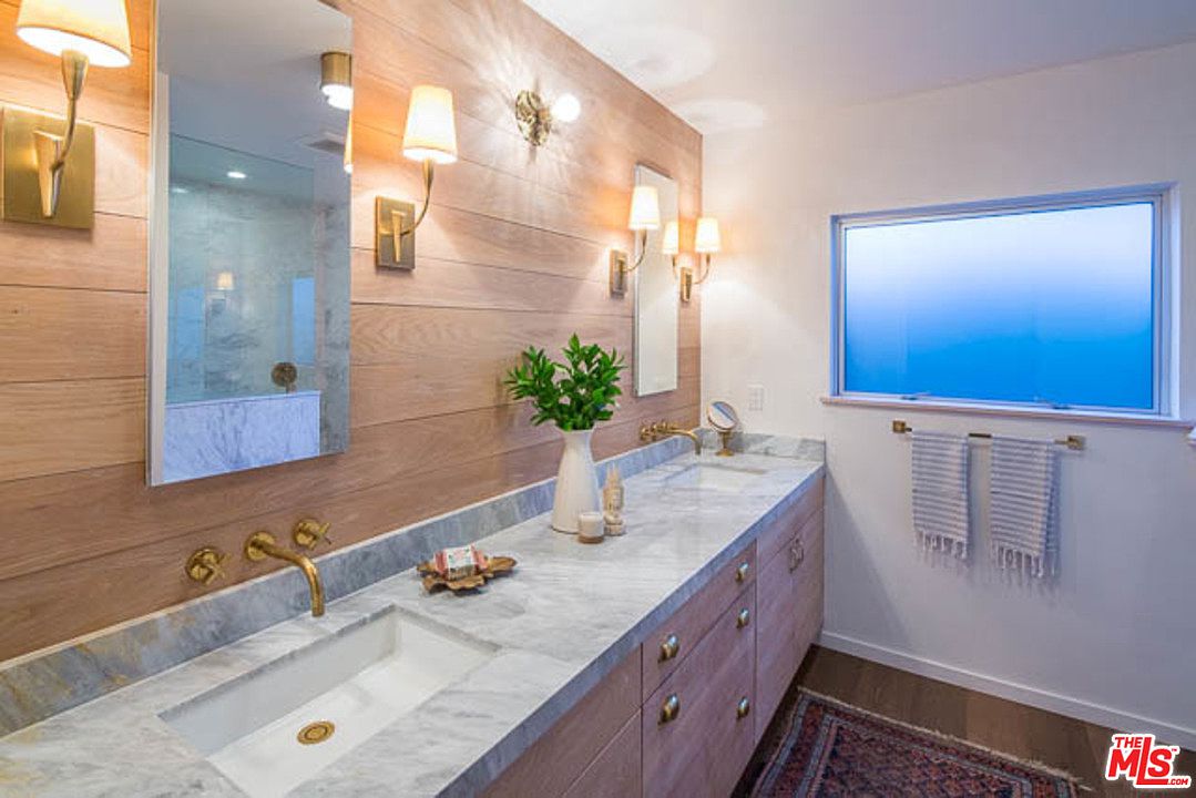 A bathroom with two sinks and a large mirror.