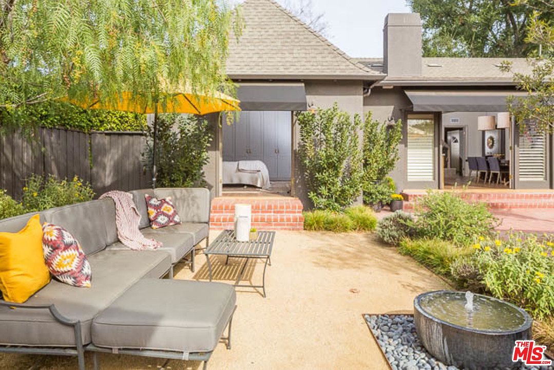 A patio with furniture and an umbrella.