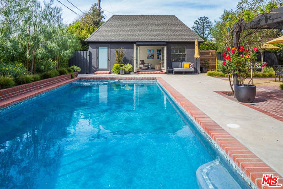 A pool with a house in the background