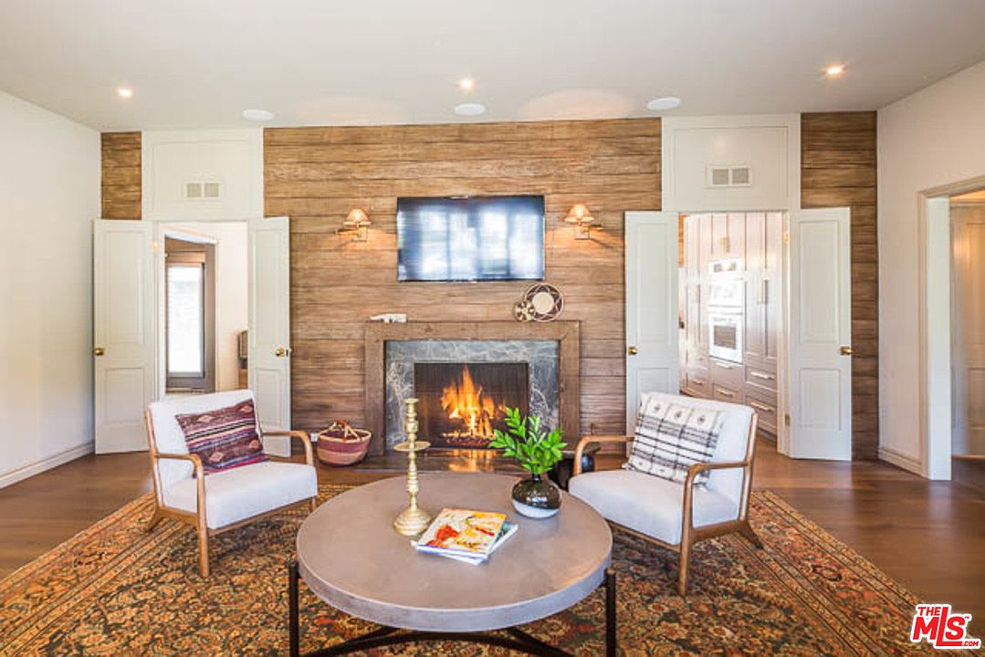 A living room with two chairs and a fireplace.