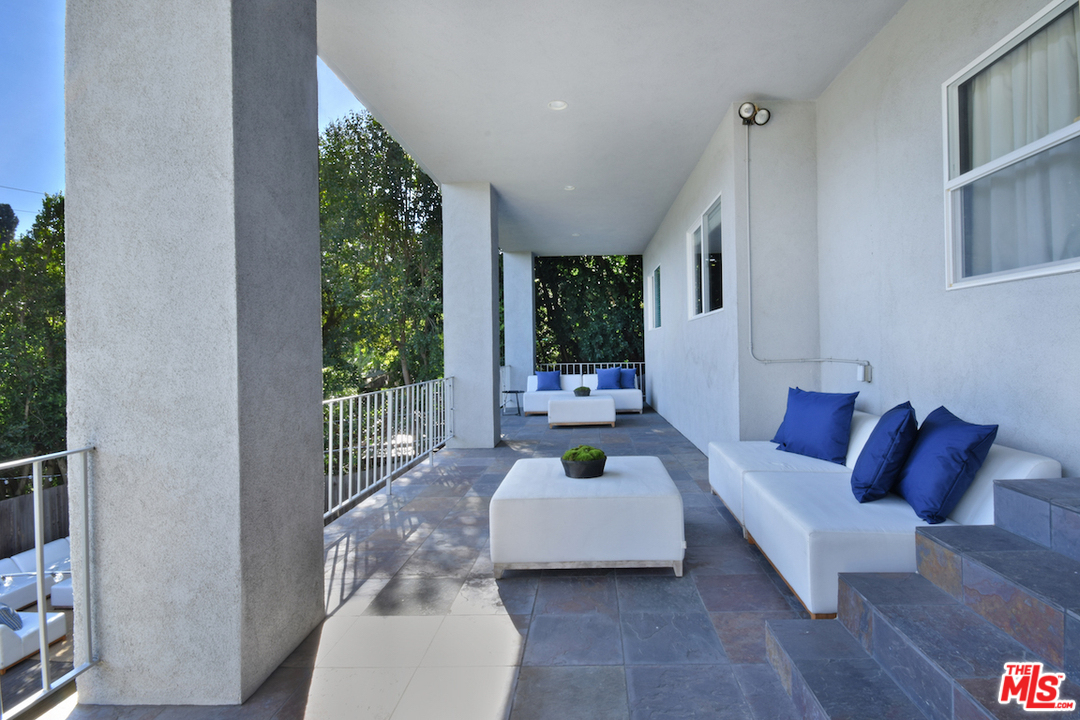 A white couch and table in an outdoor room.