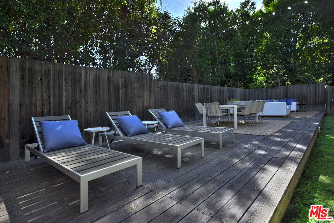 A deck with several lounge chairs and tables.