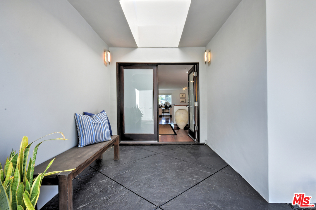 A bench in the middle of a room with a sliding glass door.