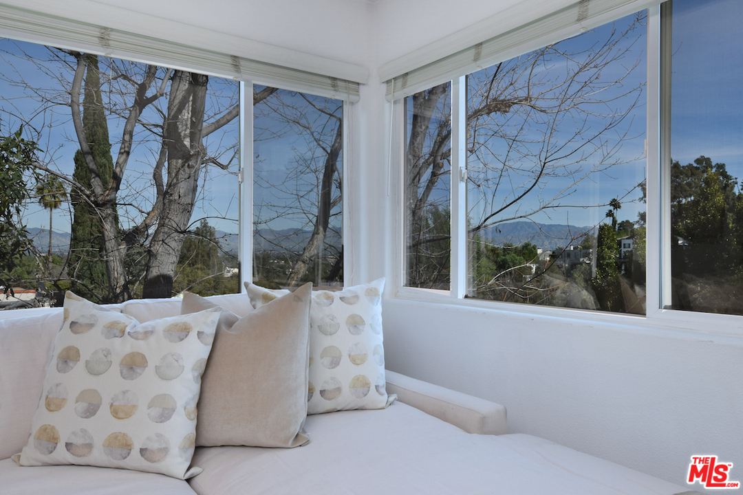 A bed room with two windows and pillows