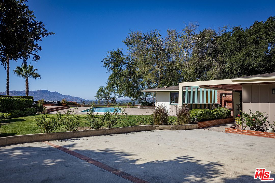 A house with a pool and trees in the background