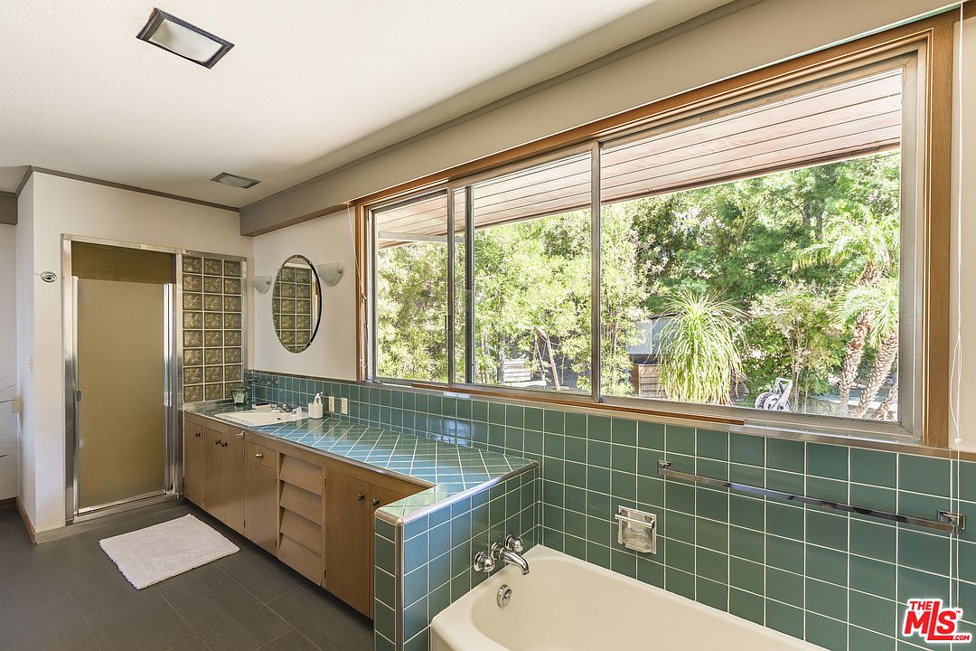 A bathroom with two sinks and a tub.