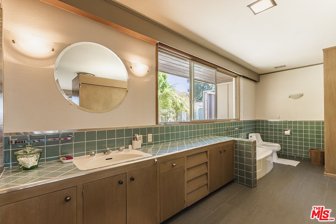 A bathroom with two sinks and a large mirror.