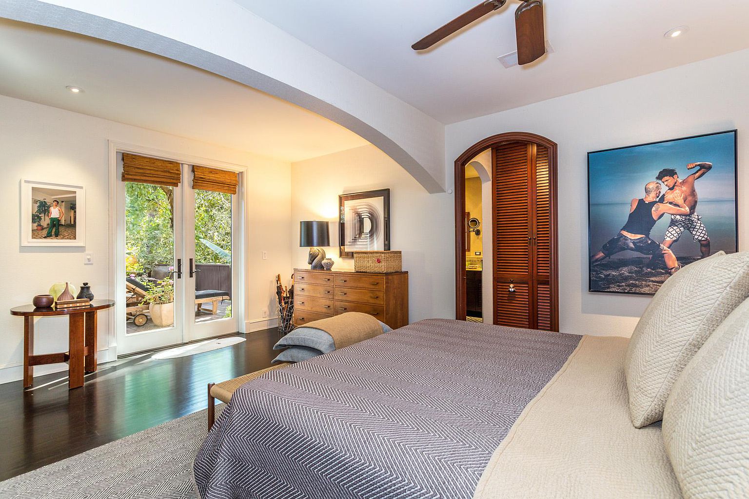 A bedroom with a bed, chair and window.