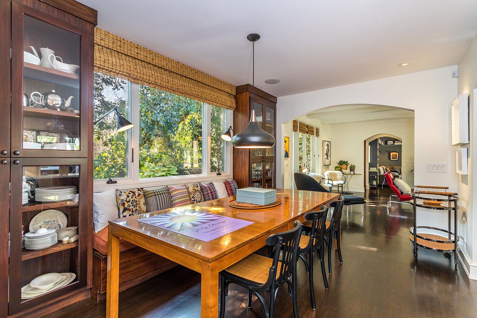 A dining room table with a bowl of fruit on it.