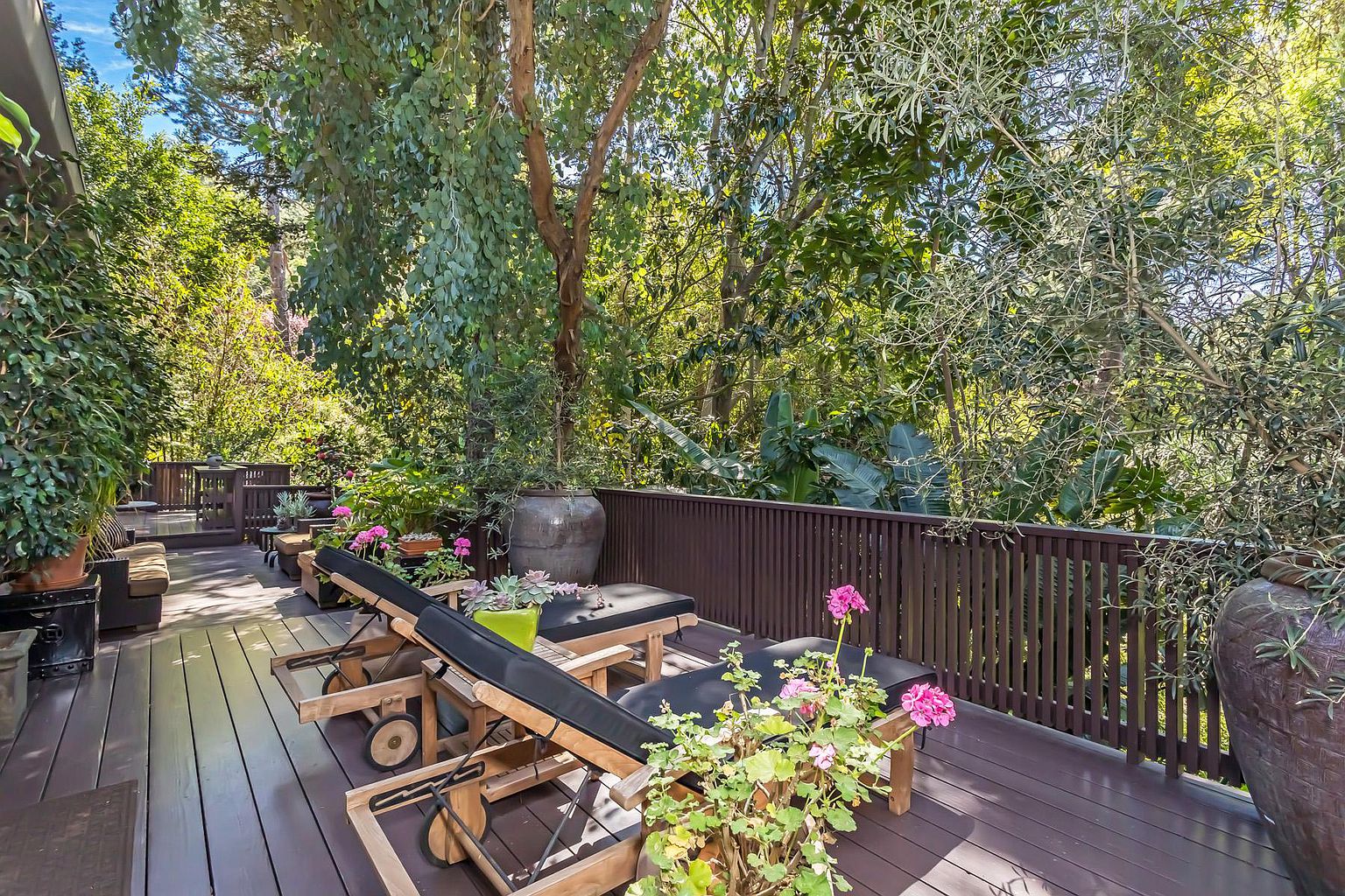 A wooden deck with tables and benches on it.