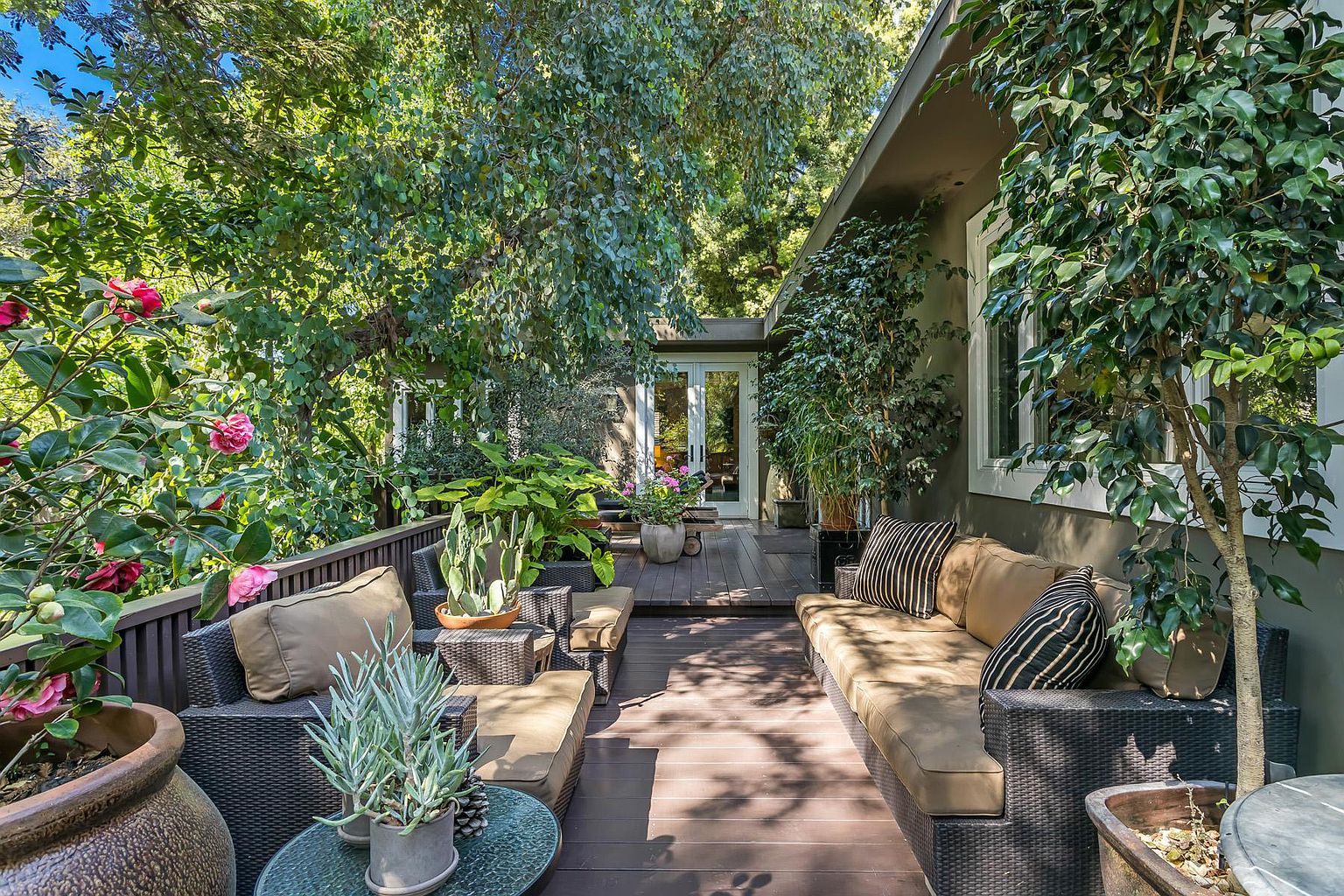 A patio with lots of furniture and plants.