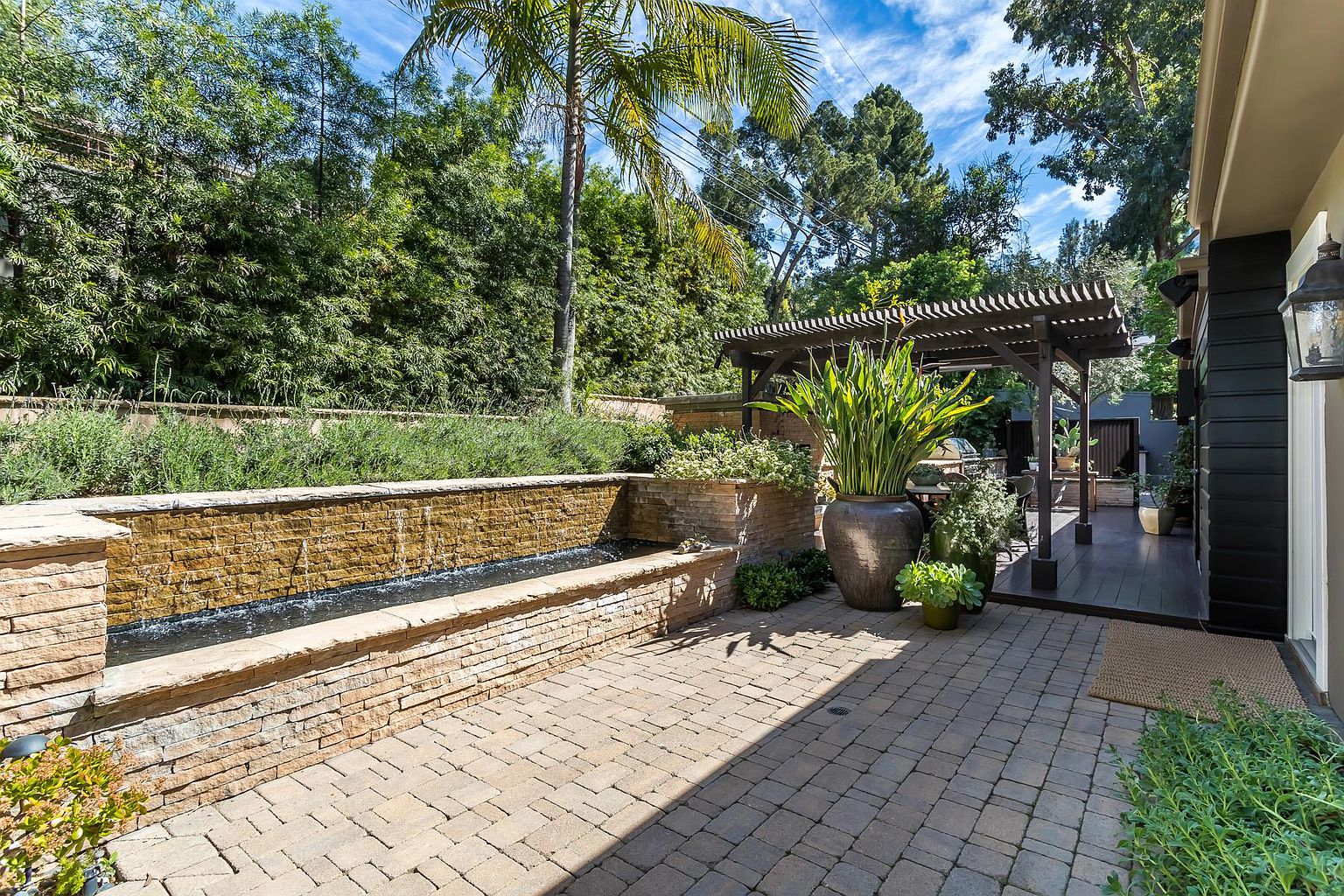 A brick patio with trees and bushes in the background.