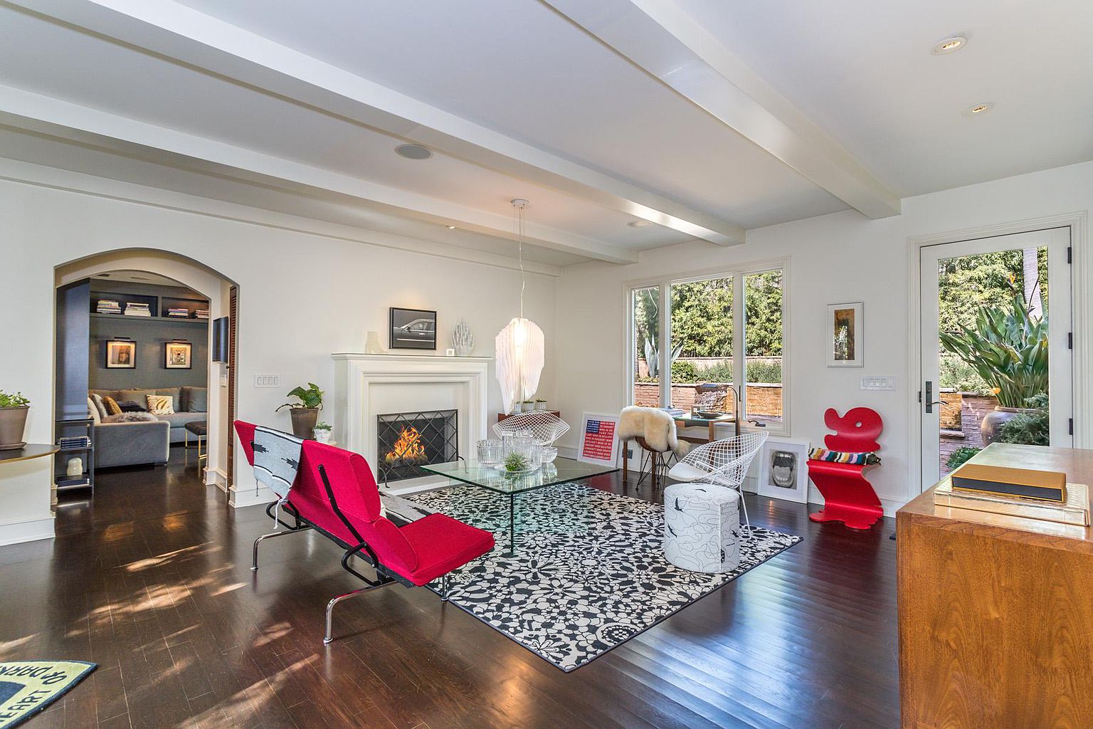 A living room with red chairs and a fireplace.