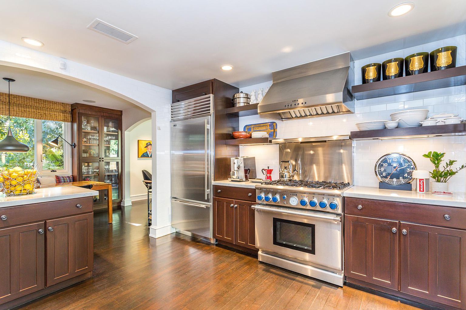 A kitchen with wooden floors and stainless steel appliances.