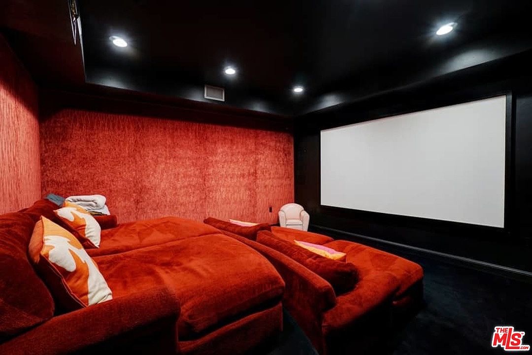 A room with two red couches and a projector screen.