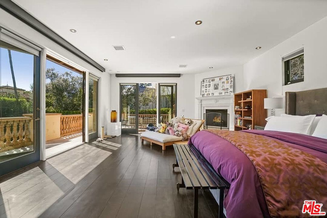 A bedroom with a large bed and a fireplace.