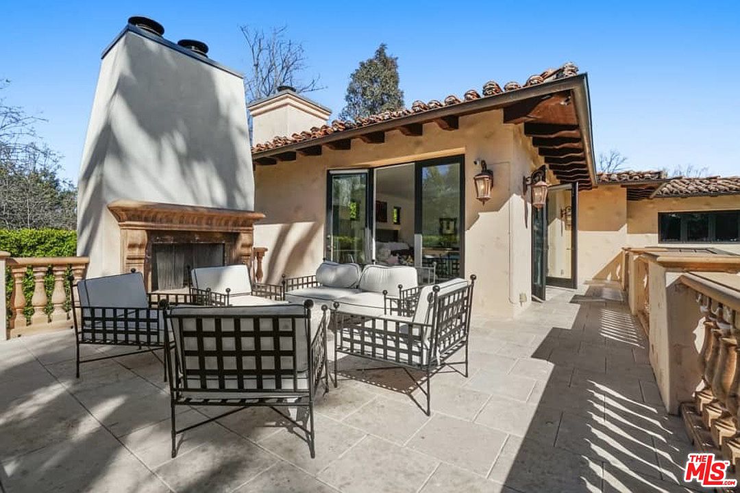 A patio with chairs and tables outside of the house.