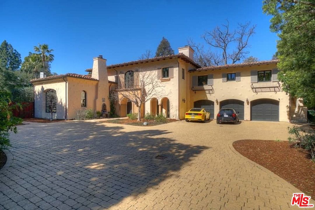 A large driveway with a car parked in front of it.