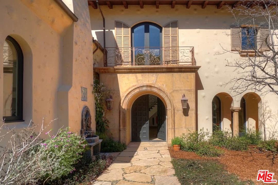 A stone walkway leading to the entrance of a house.