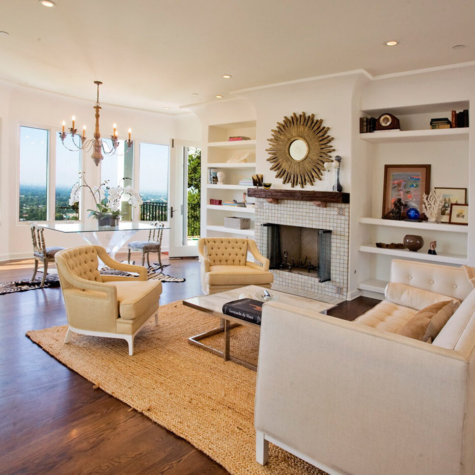 A living room with white furniture and wood floors.